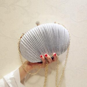 565312066 woman holding sparkly clutch handbag at night event